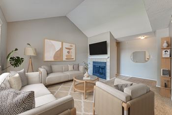 A living room with a fireplace and a TV on the wall.